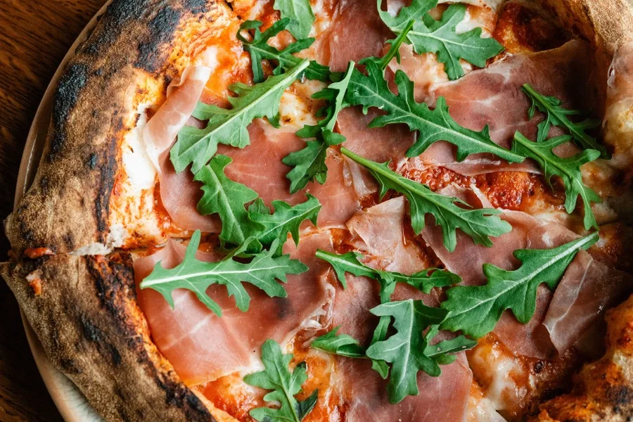 Wood-fired Neapolitan pizza topped with prosciutto di Parma and arugula